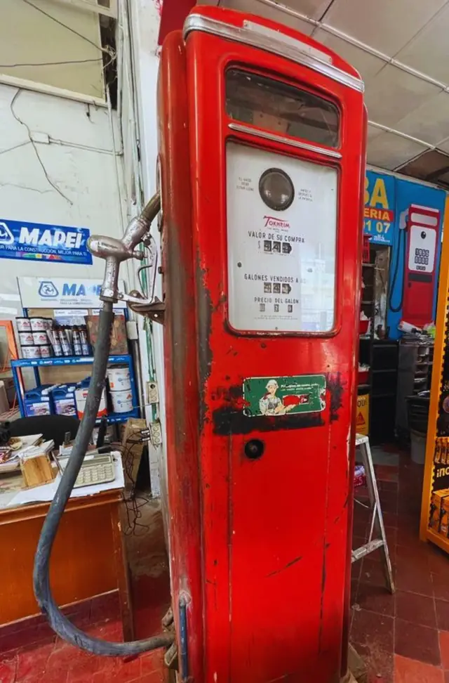 Antigua bomba de gasolina Tokheim, roja, dentro de la tienda La Bomba
